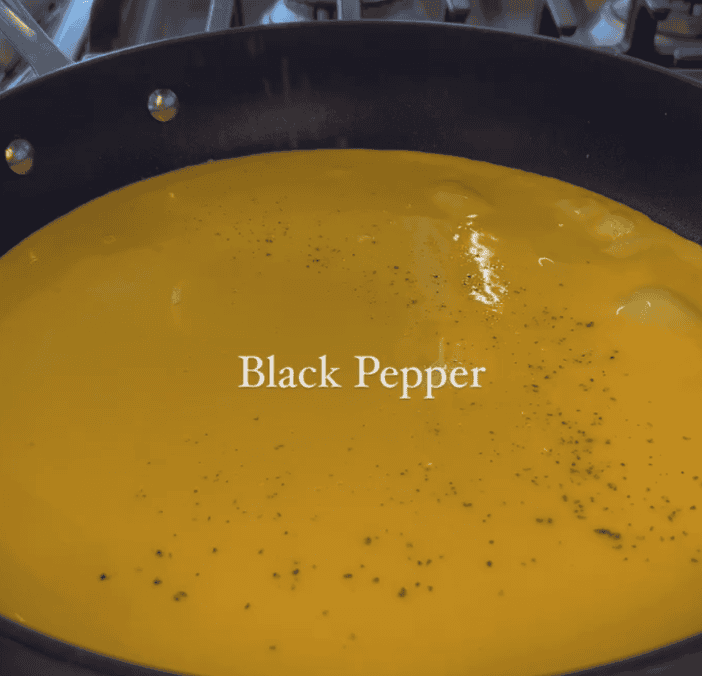black pepper on eggs in pan